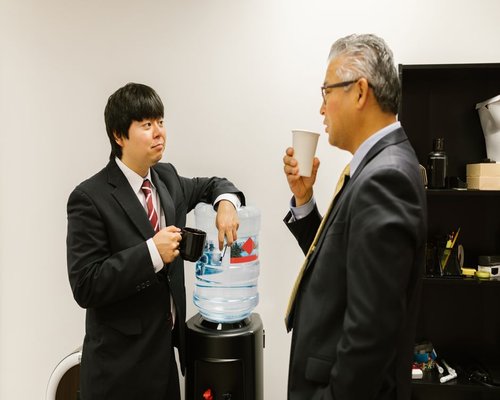 Colleagues taking a break at the office near a water cooler