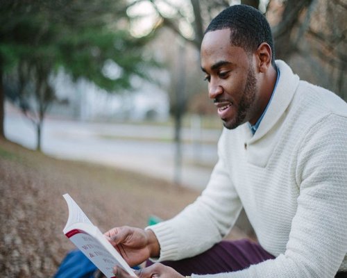 Person reading a book and relaxing in a park